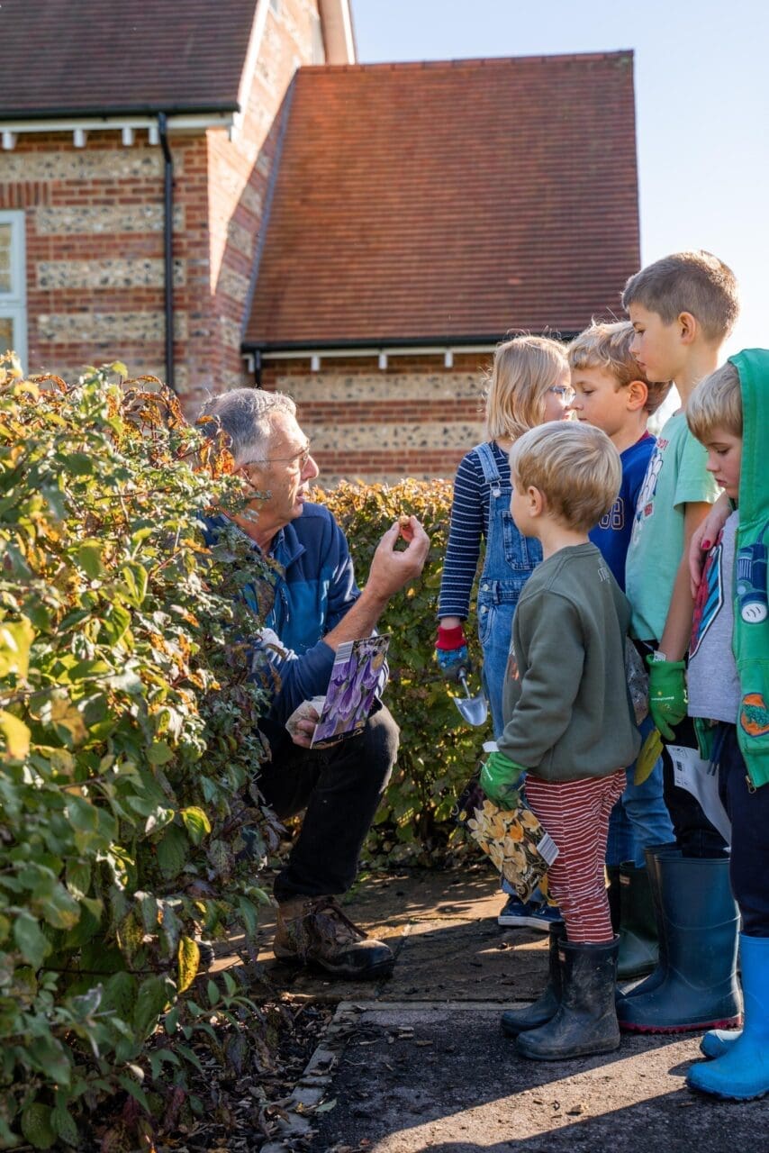 Children help to plant spring bulbs in the community garden.